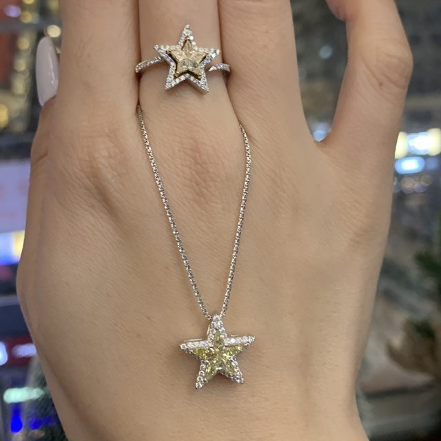 Star ring and matching star pendant with yellow diamonds, worn on a hand